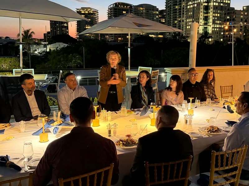 Tarja Stephens speaking at a rooftop dinner in Miami at dusk