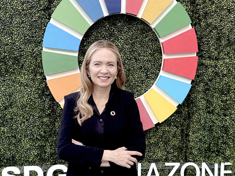 Tarja Stephens in front of the Sustainable Development Goals wheel at the SDG Media Zone