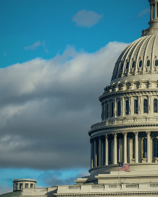 The dome of the United States Capitol under a blue sky.