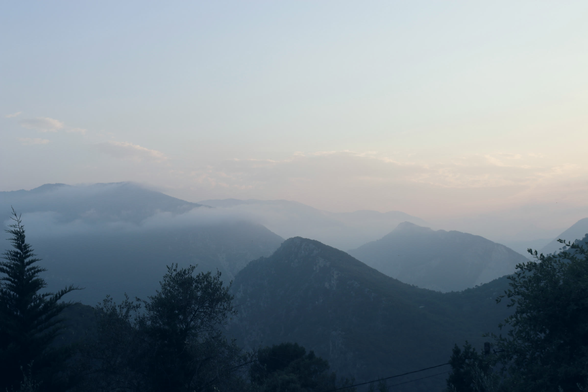 Misty ridges fading into a pale sky.