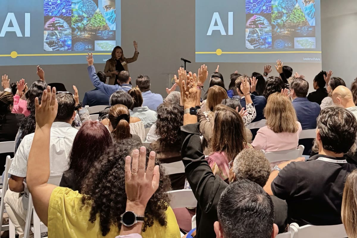 Tarja Stephens leading a session on AI while the participants raise their hands.